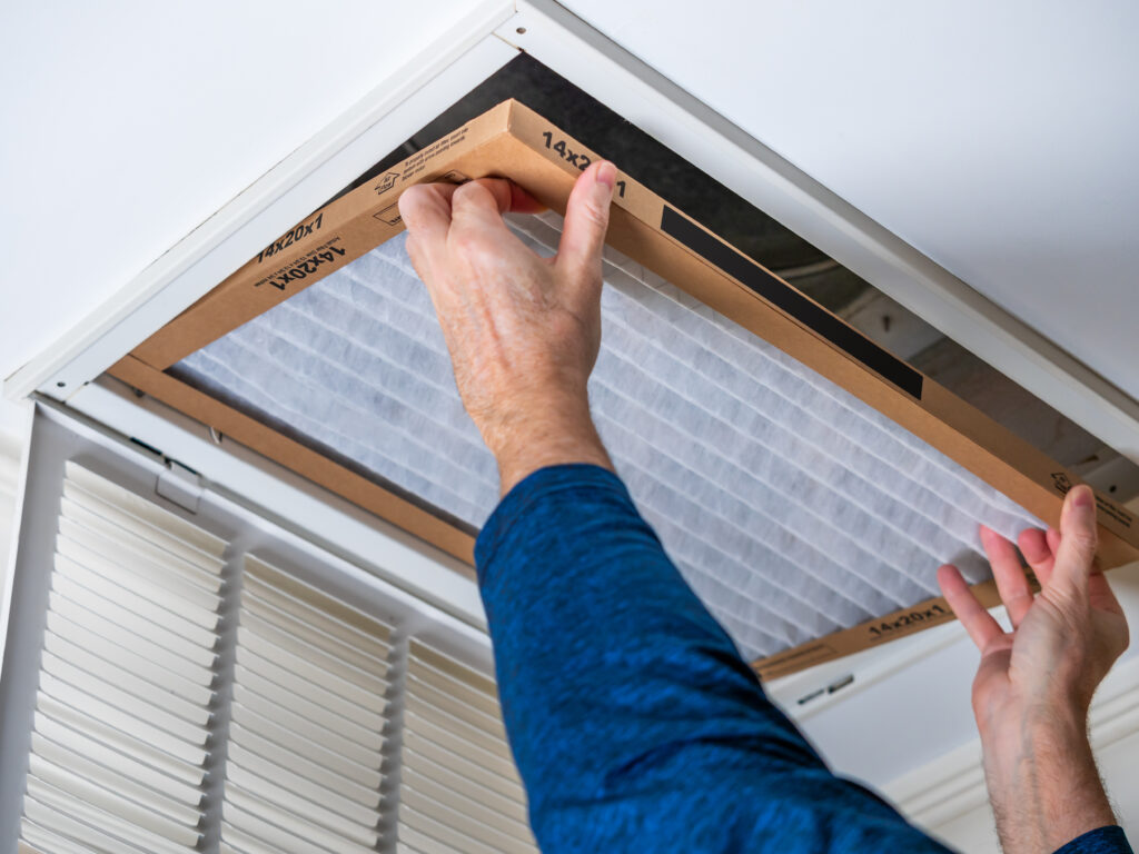 HVAC technician replacing a home air filter in Fair Oaks