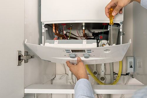 Heating technician repairing a residential boiler in Fair Oaks
