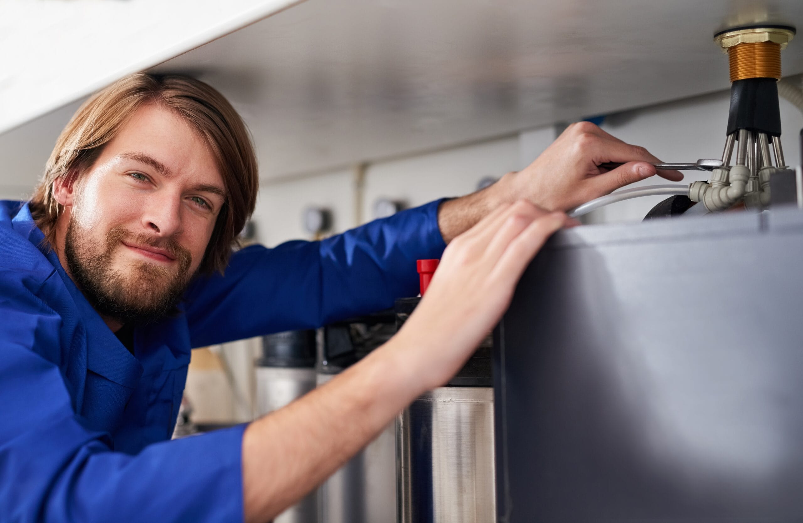 Technician servicing a residential water heater tank in Fair Oaks